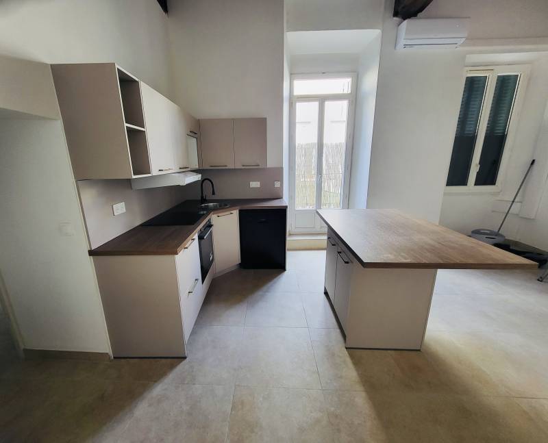 Cuisiniste Manosque pour pose d'ilot central en bois et évier en coin du plan de travail en L