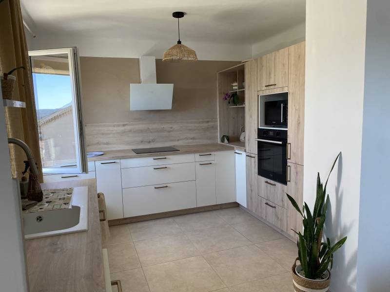 Installateur de cuisine à Volx blanche et bois stratifié avec four encastré et hotte aspirante inclinée